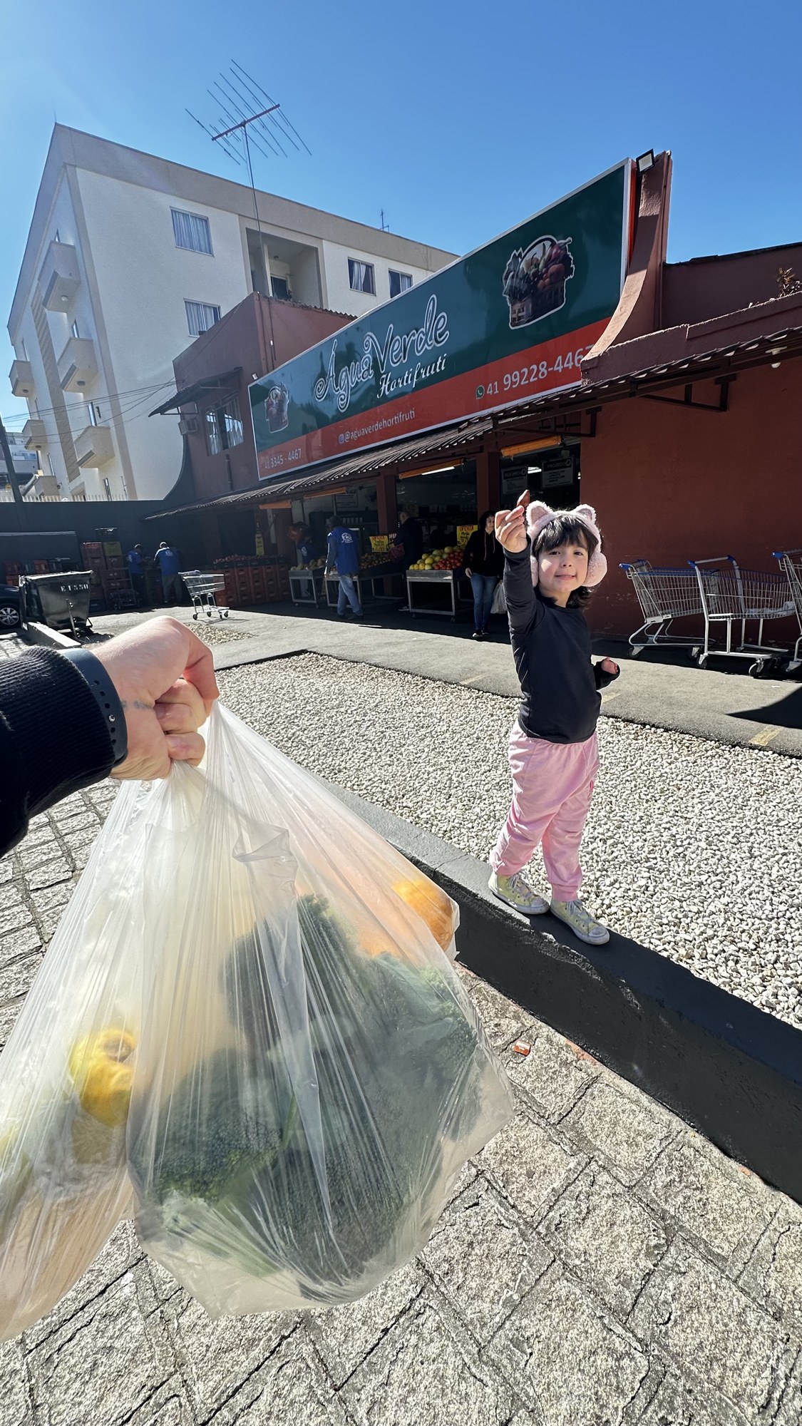 Edu e a filha Tárcila escolhendo vegetais juntos no hortifruti.
